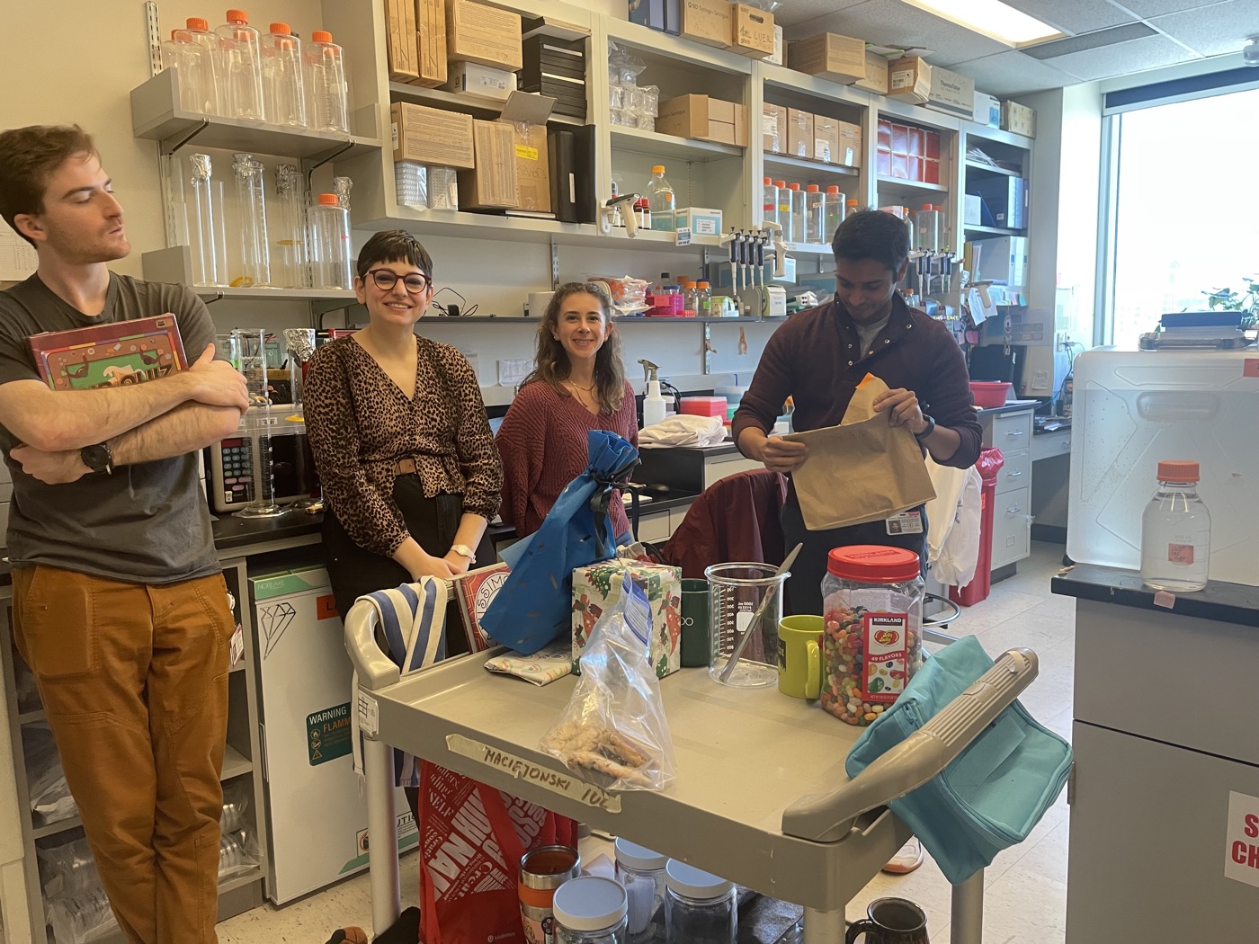 The lab gathered around a cart in the lab.