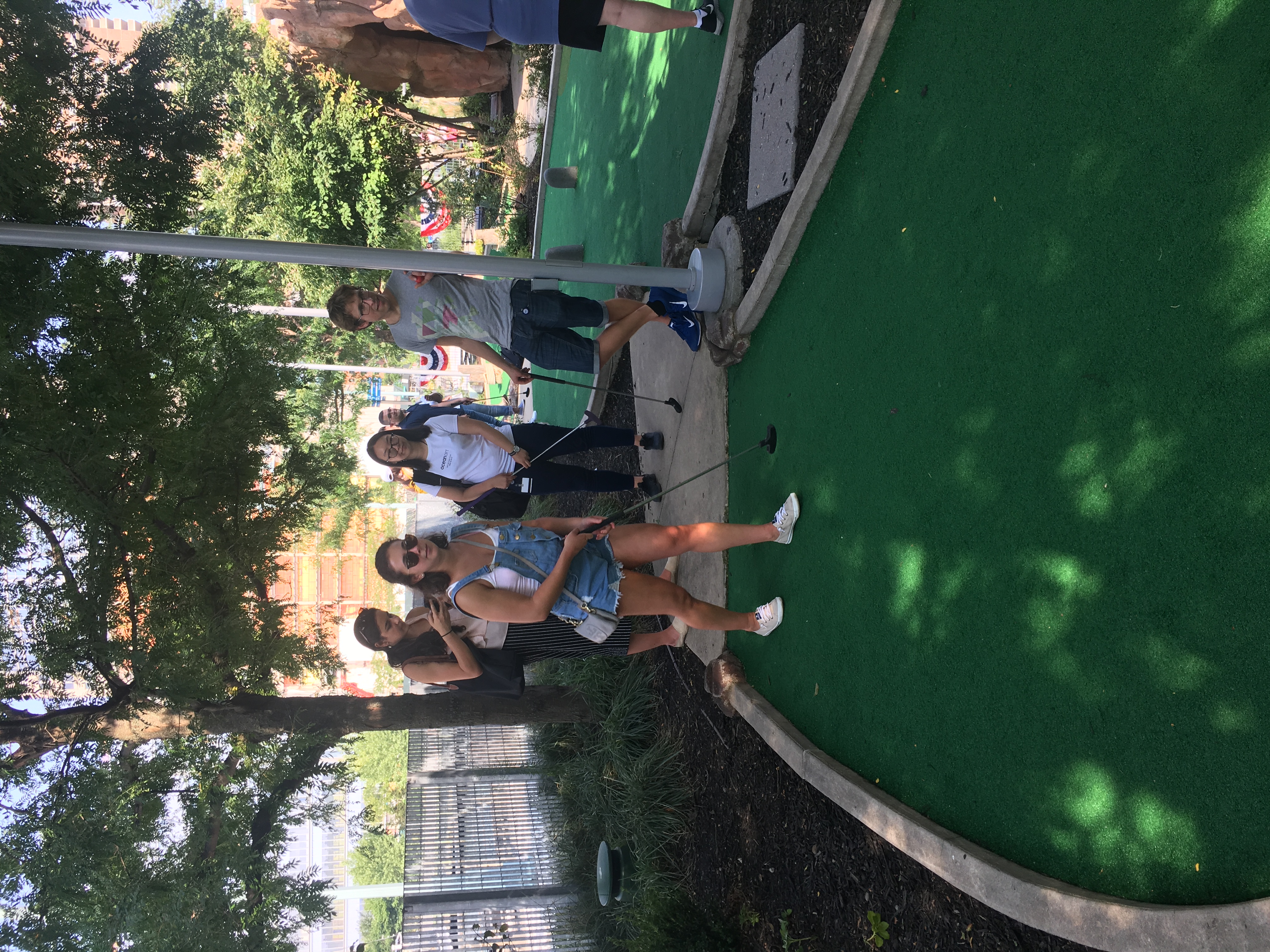 Lab members playing mini golf outdoors in summer